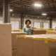 How to improve the order fulfillment process, factory worker stands surrounded by boxes